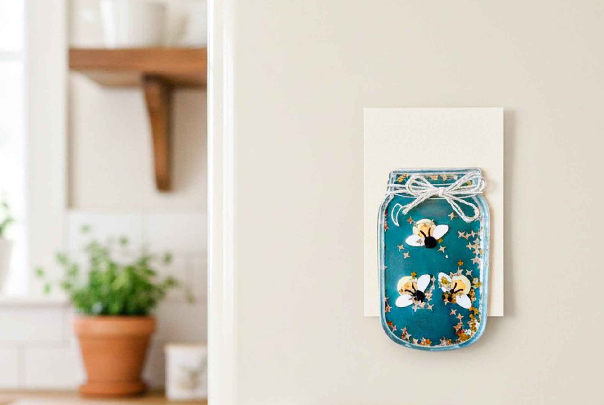 Firefly and moon magnet from Farmhouse Whimsy magnet set displayed on a fridge door. Bright, whimsical design, perfect for magnetic decor.