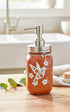 Orange hummingbird mason jar soap dispenser by Farmhouse Whimsy, featuring a decorative hummingbird design and a pump top.