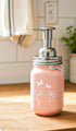 Farmhouse Whimsy butterfly mason jar soap dispenser with peach liquid soap and a butterfly design on a rustic soap jar.