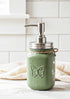 Farmhouse Whimsy butterfly mason jar soap dispenser with peach liquid soap and decorative butterfly design.
