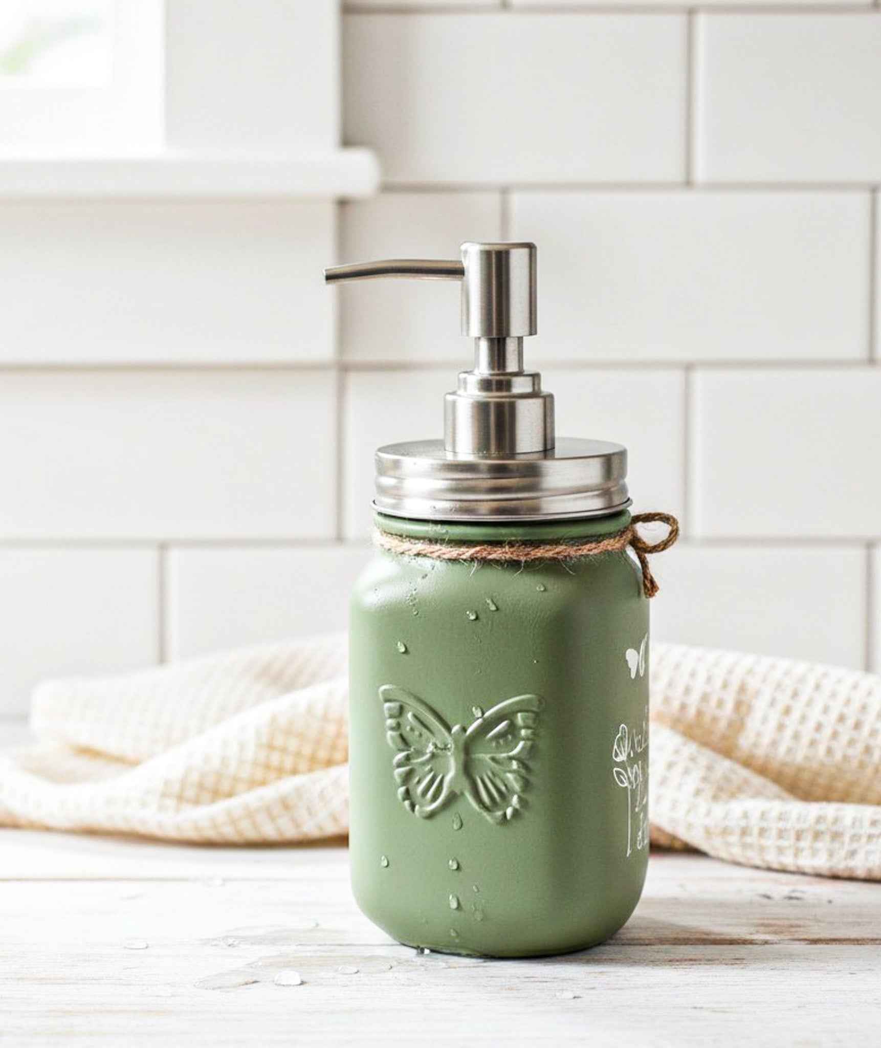 Farmhouse Whimsy butterfly mason jar soap dispenser with peach liquid soap and decorative butterfly design.