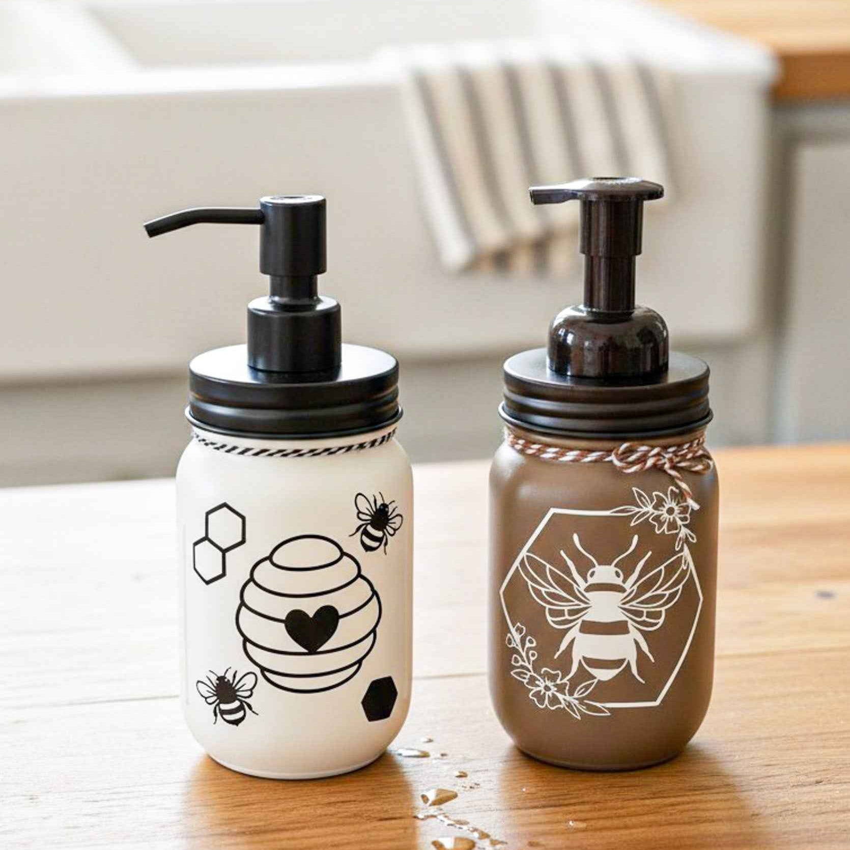 Cream and black Honey Bee Mason Jar soap pump from Farmhouse Whimsy filled with liquid soap and featuring a mason jar design.