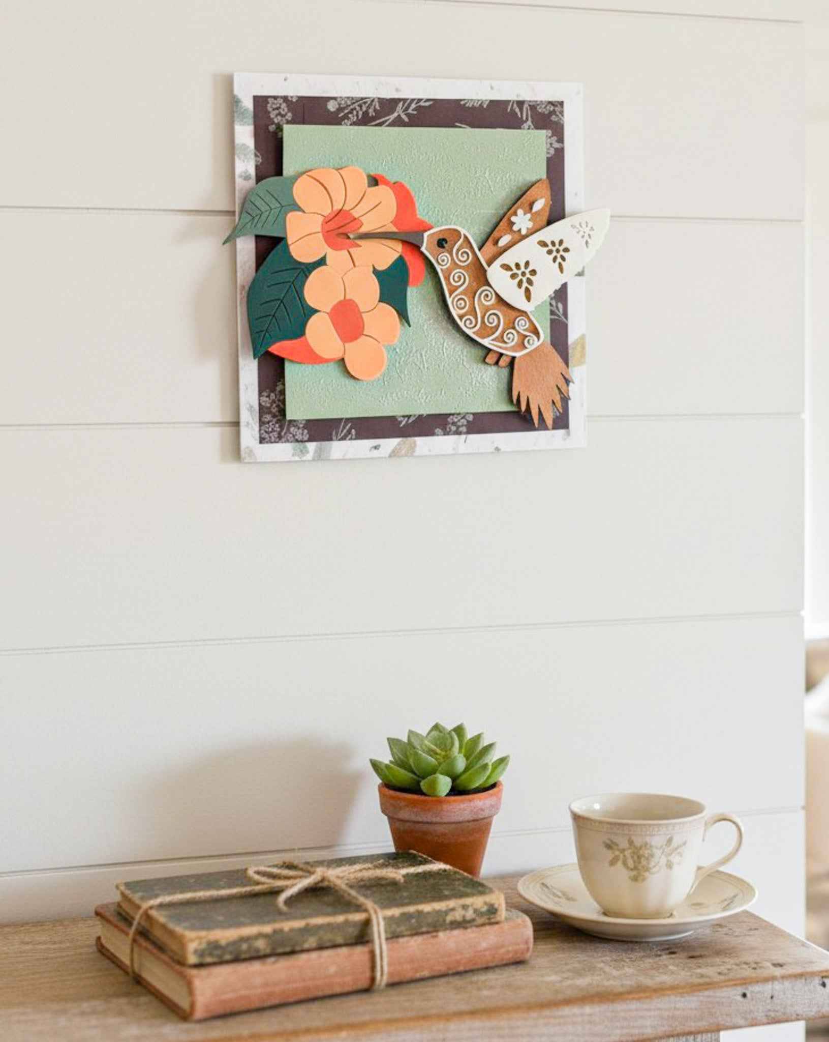 Hummingbird Trumpet Vine Wall Art by Farmhouse Whimsy featuring colorful hummingbird and trumpet vine design on textured wall.