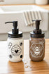Cream and black Honey Bee Mason Jar soap pump from Farmhouse Whimsy filled with liquid soap and featuring a mason jar design.