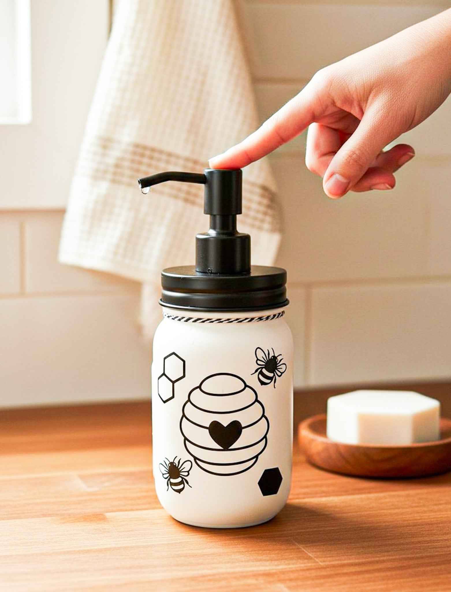Cream-colored honey bee mason jar soap pump by Farmhouse Whimsy, decorative glass soap jar with black pump and rustic design.