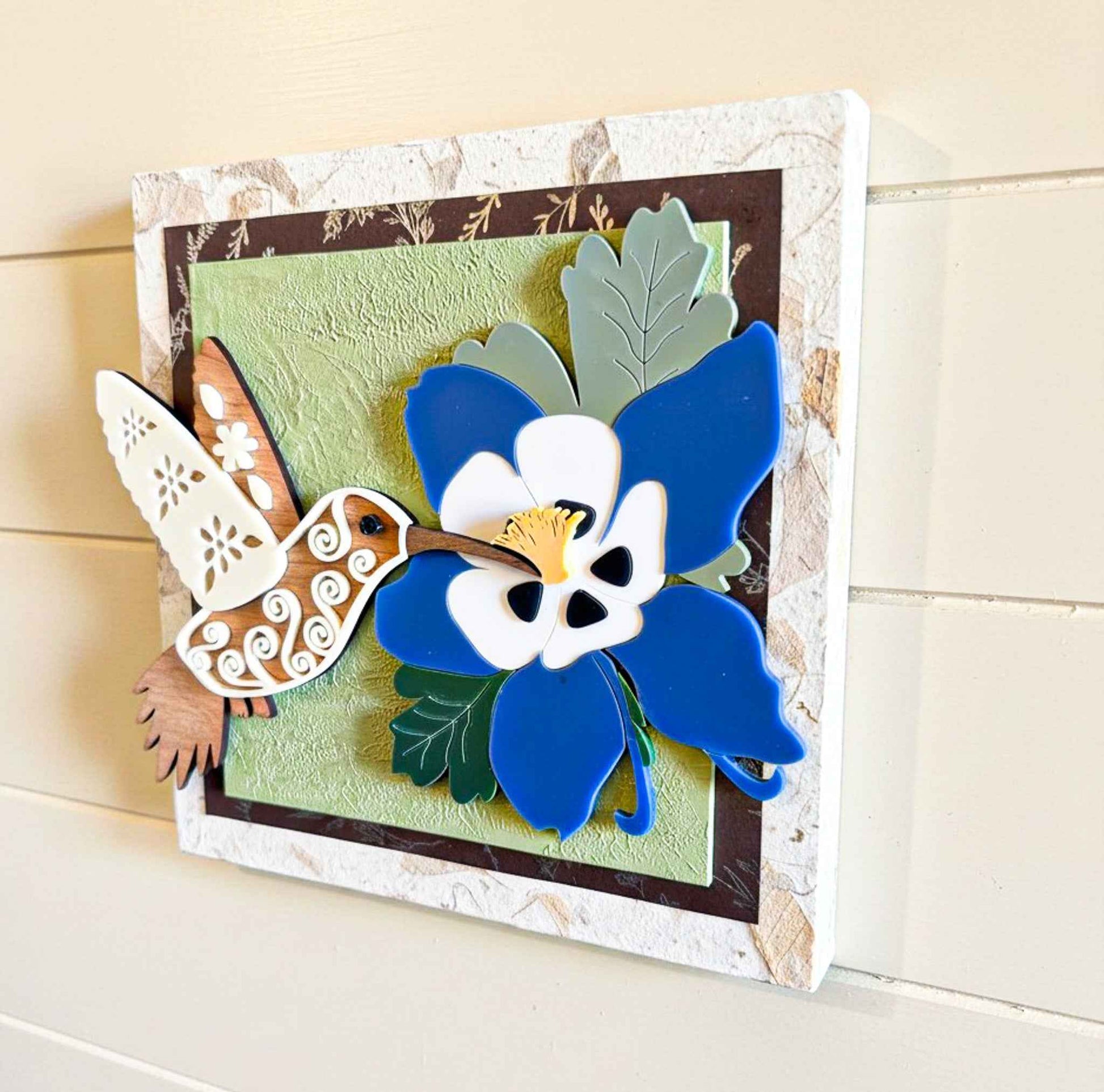 Hummingbird and columbine flower wall art by Farmhouse Whimsy featuring colorful nature scene on a decorative wall art piece