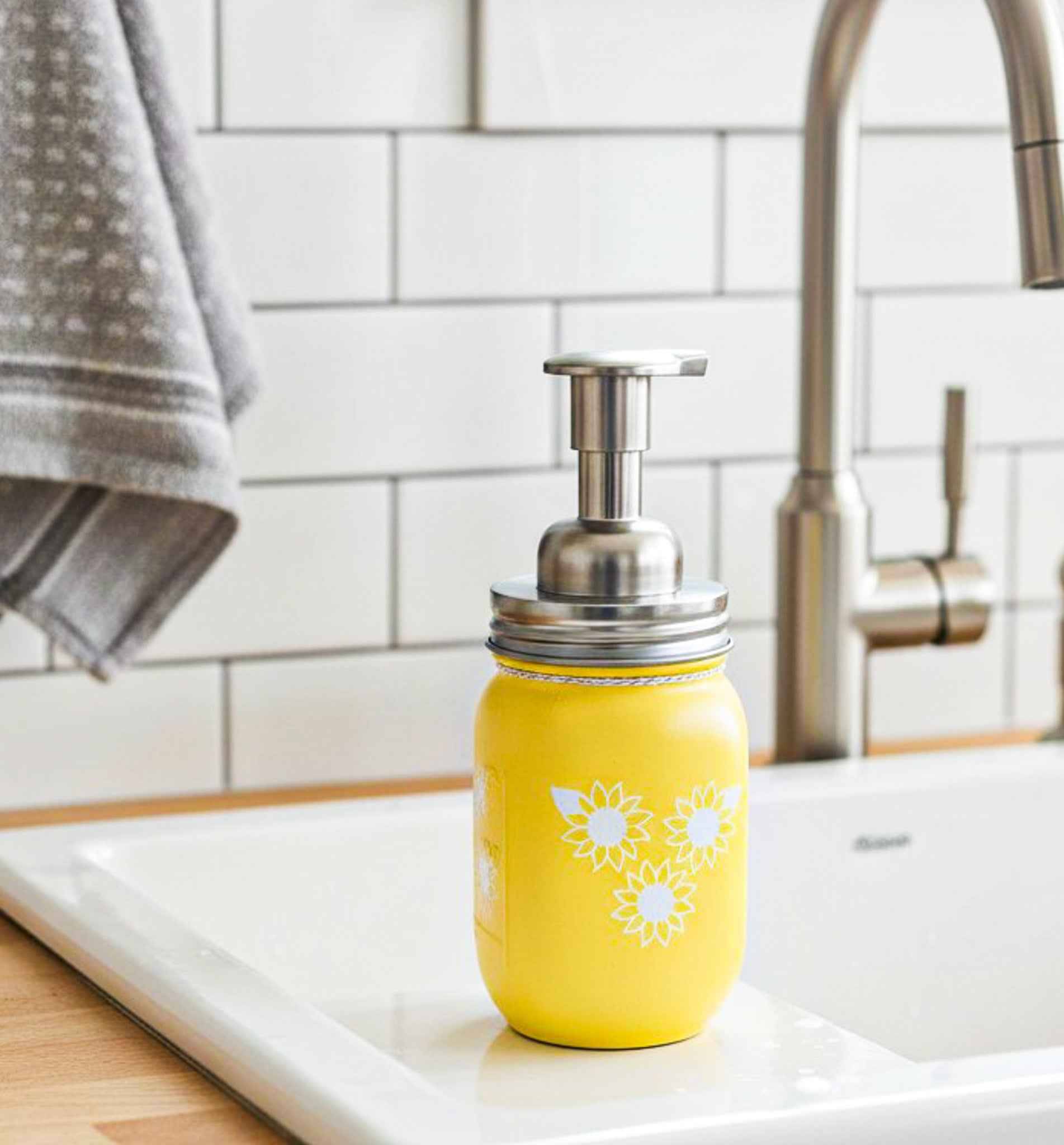 Farmhouse Whimsy sunflower mason jar soap dispenser on a countertop, rustic style soap jar with sunflower design.